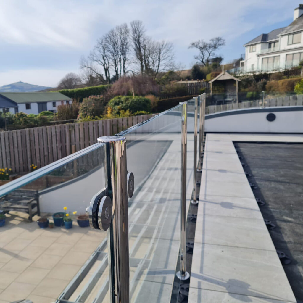 Glass balustrade using the watertight stanchion mounts on a flat roof structure